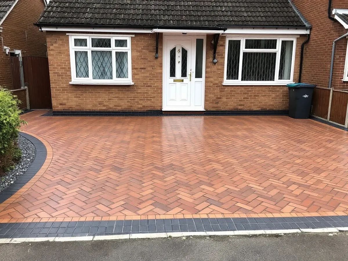New herringbone block paving driveway in front of a brick house